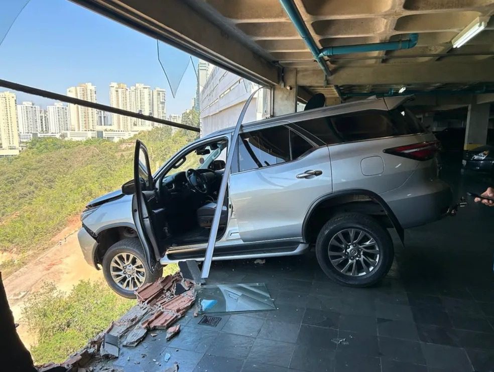 VÍDEO: Carro bate em muro de estacionamento e fica pendurado em prédio